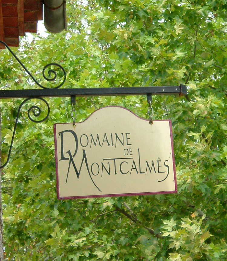 Enseigne du Domaine de Montcalmès devant un feuillage